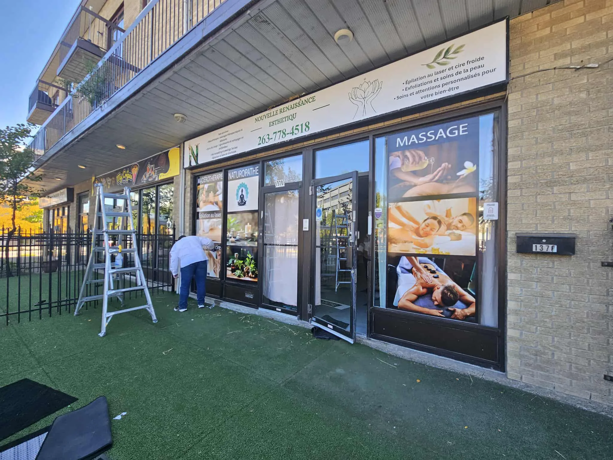 Commercial perforated window graphics applied to Montreal storefront glass — Max Printing window vinyl installation